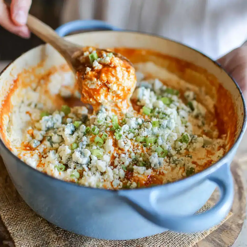 Mixing cottage cheese and chicken for buffalo dip